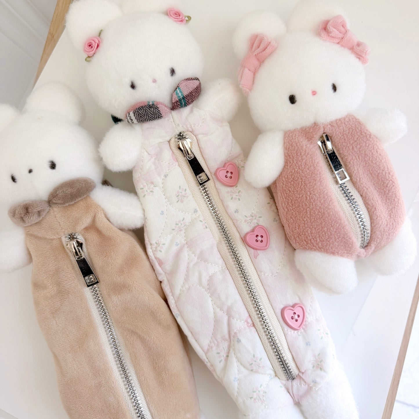 Three differently sized multicolored bunny pouches on white surface