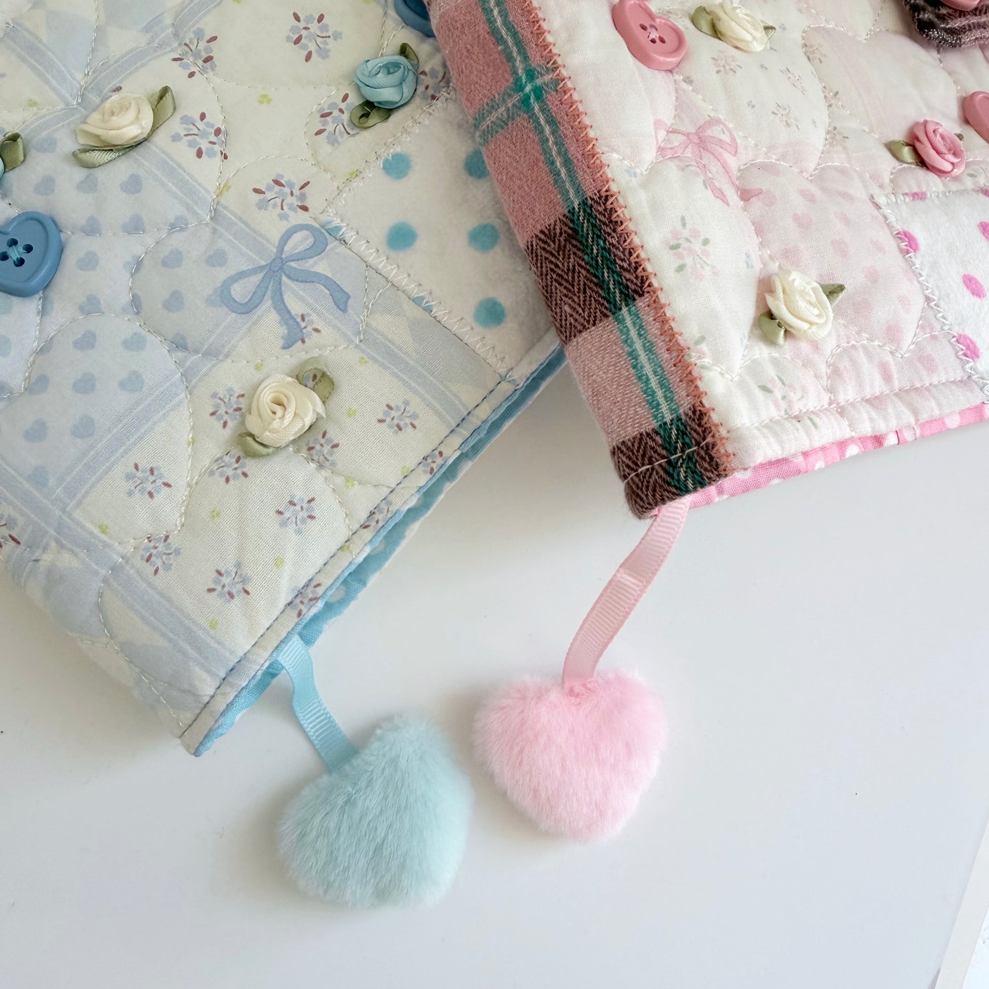 Blue and Pink A5 fabric journal cover bookmarks with fuzzy hearts on a white surface
