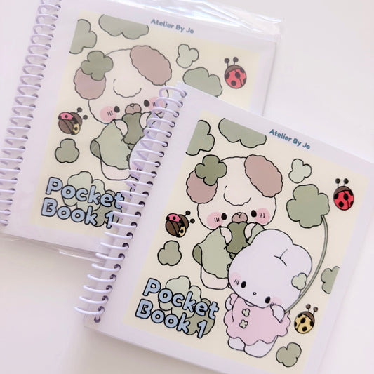 Two spiral-bound notebooks with cute illustrations and 'Pocket Book 1' text on a white background.