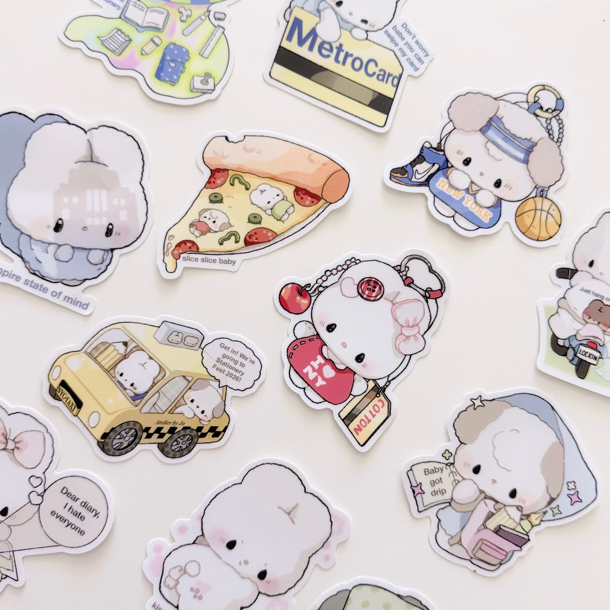 A collection of cute cartoon character stickers scattered on a light background. The characters include a white fluffy bunny in a gray hoodie, a slice of pizza with small food characters, a yellow taxi cab with a driver, a white cat in a red apron holding a shopping bag, and other playful illustrated scenes.