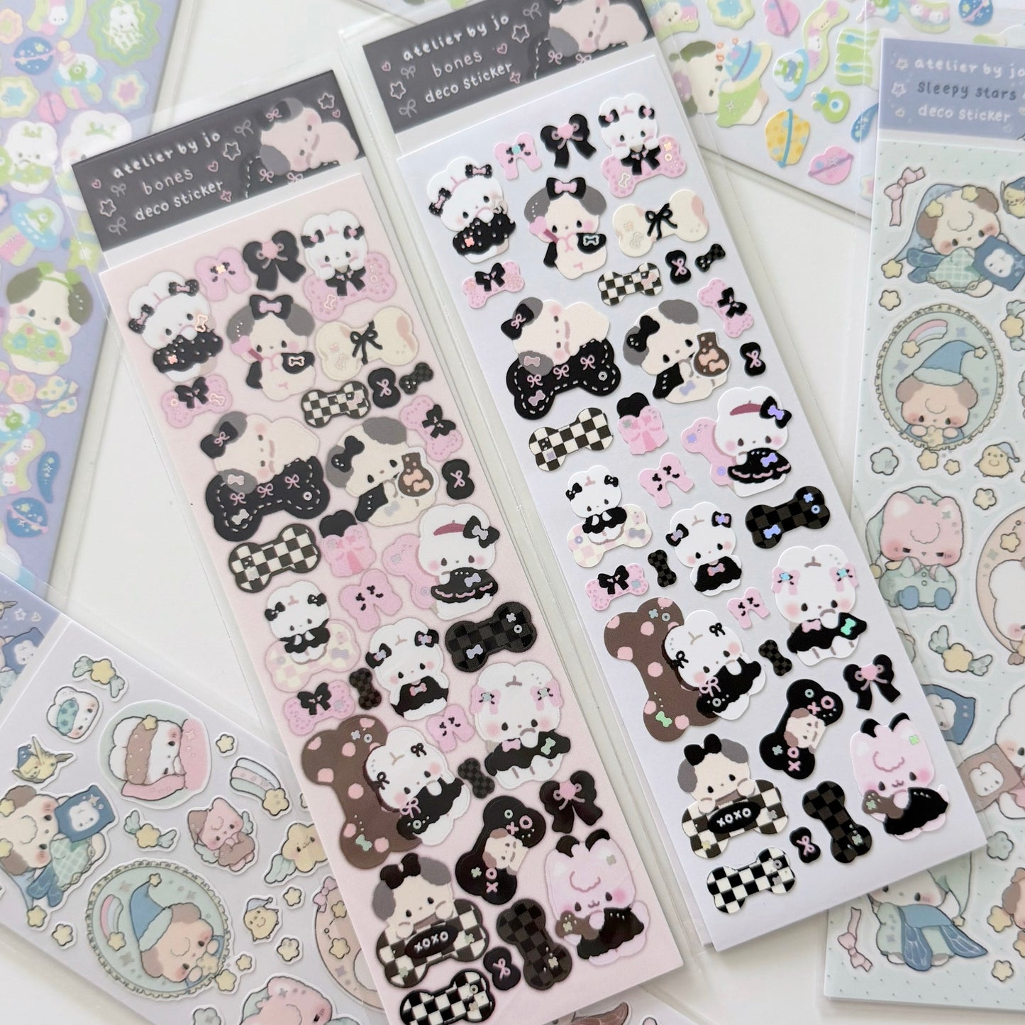 Several sheets of cute cartoon sticker characters, mostly black-and-white and pink-and-white designs, arranged on a pastel background. The header cards read 'doodle by jo' and 'cute sticker'.