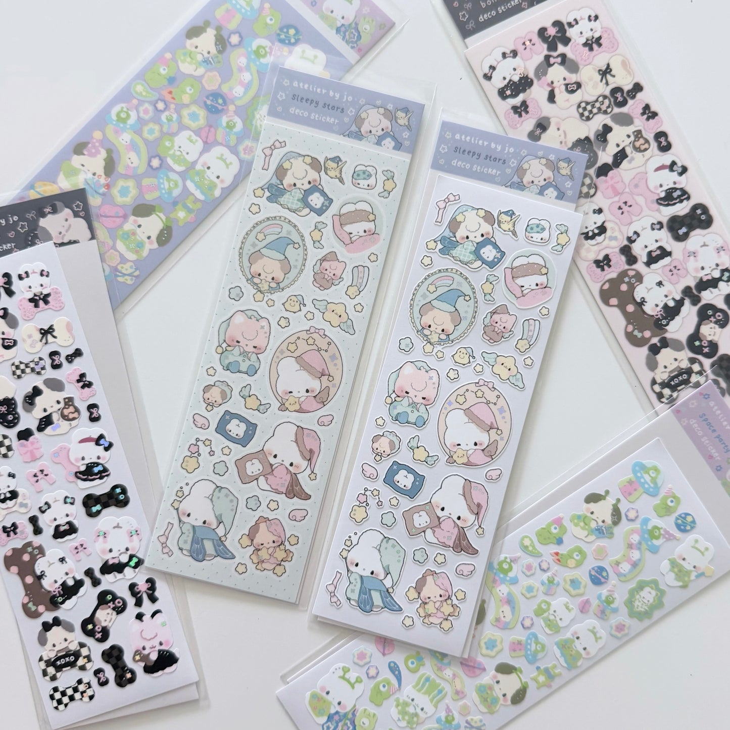 Several sheets of cute cartoon stickers arranged on a white surface. The sheets feature pastel illustrations including a pink bunny, bears, flowers, stars, and small decorative motifs.