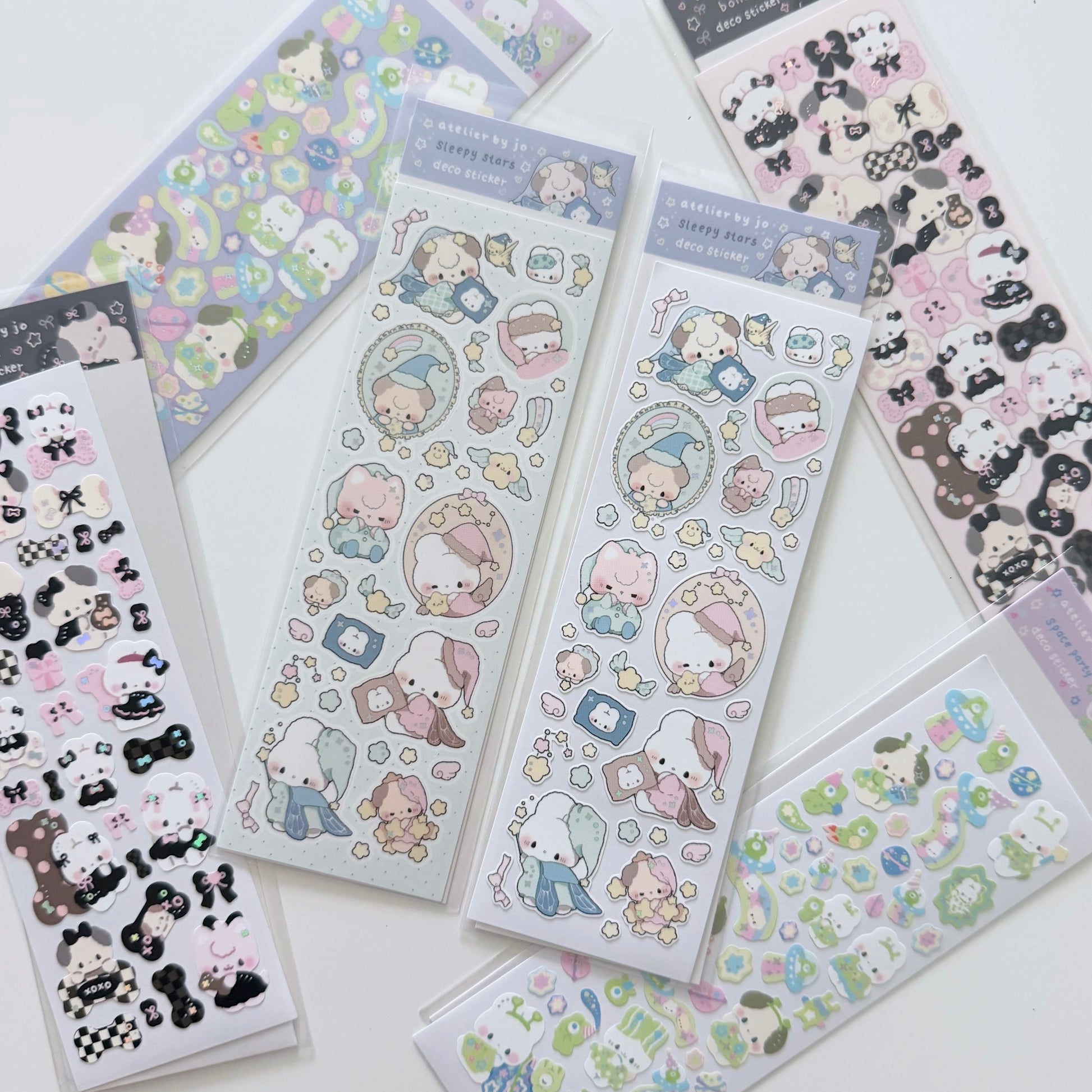 Several sheets of cute cartoon stickers arranged on a white surface. The sheets feature pastel illustrations including a pink bunny, bears, flowers, stars, and small decorative motifs.